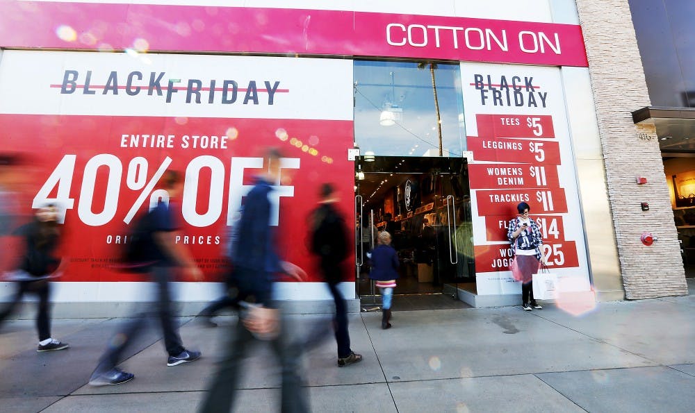 Shoppers flock to a store advertising steep discounts along the Third Street Promenade in Santa Monica, Calif., on Friday, Nov. 27, 2015. (Luis Sinco/Los Angeles Times/TNS)