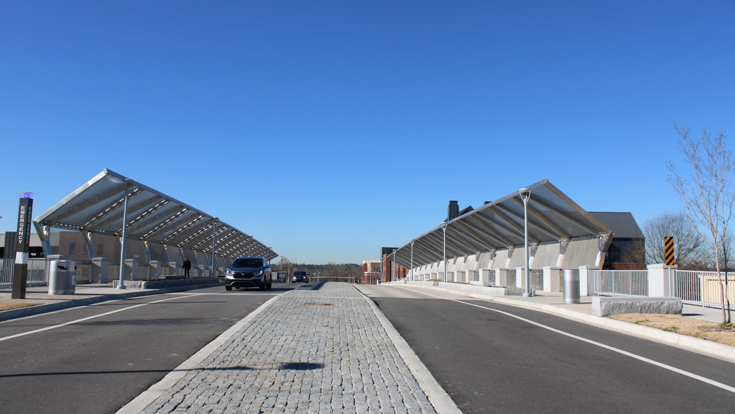 Two cars rushing by as a person walks across the Greene Street bridge on Jan. 24, 2023. The new bridge had its grand opening on Dec. 7, 2022, after three years of construction. 