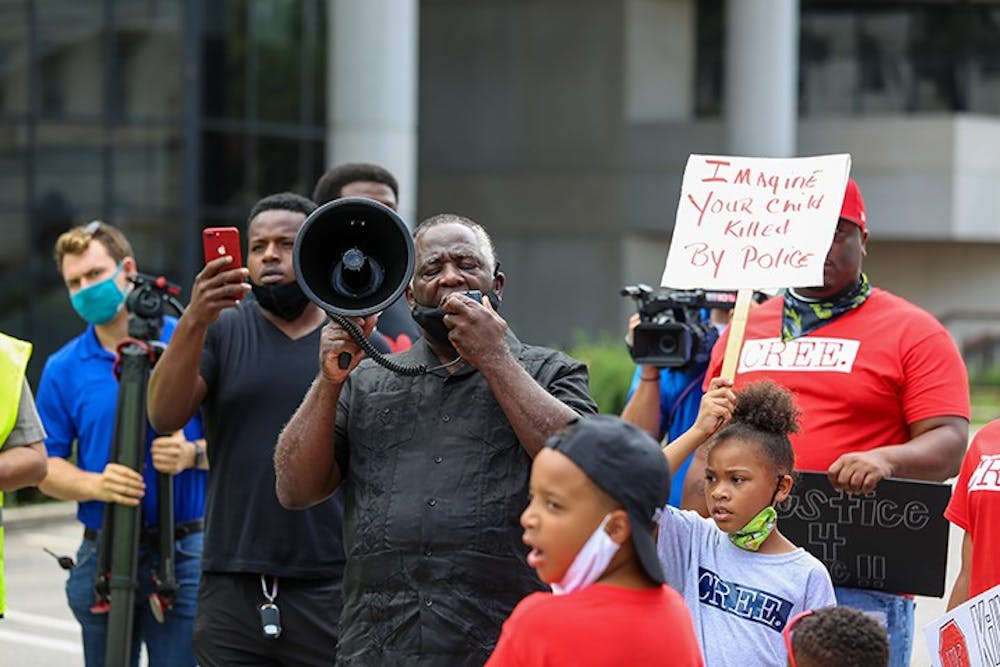 <p>Elder James Johnson speaks to a crowd outside the judicial center. The protesters started at the Statehouse and marched through the streets of downtown Columbia.</p>
