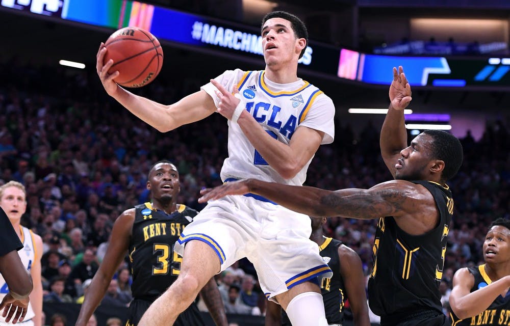 UCLA's Lonzo Ball, middle, scores a basket and draws a foul against Kent State's Kevin Zabo during the first half in the first round of the NCAA Tournament at the Golden 1 Center in Sacramento, Calif., on Friday, March 17, 2017. UCLA advanced, 97-80. (Wally Skalij/Los Angeles Times/TNS)