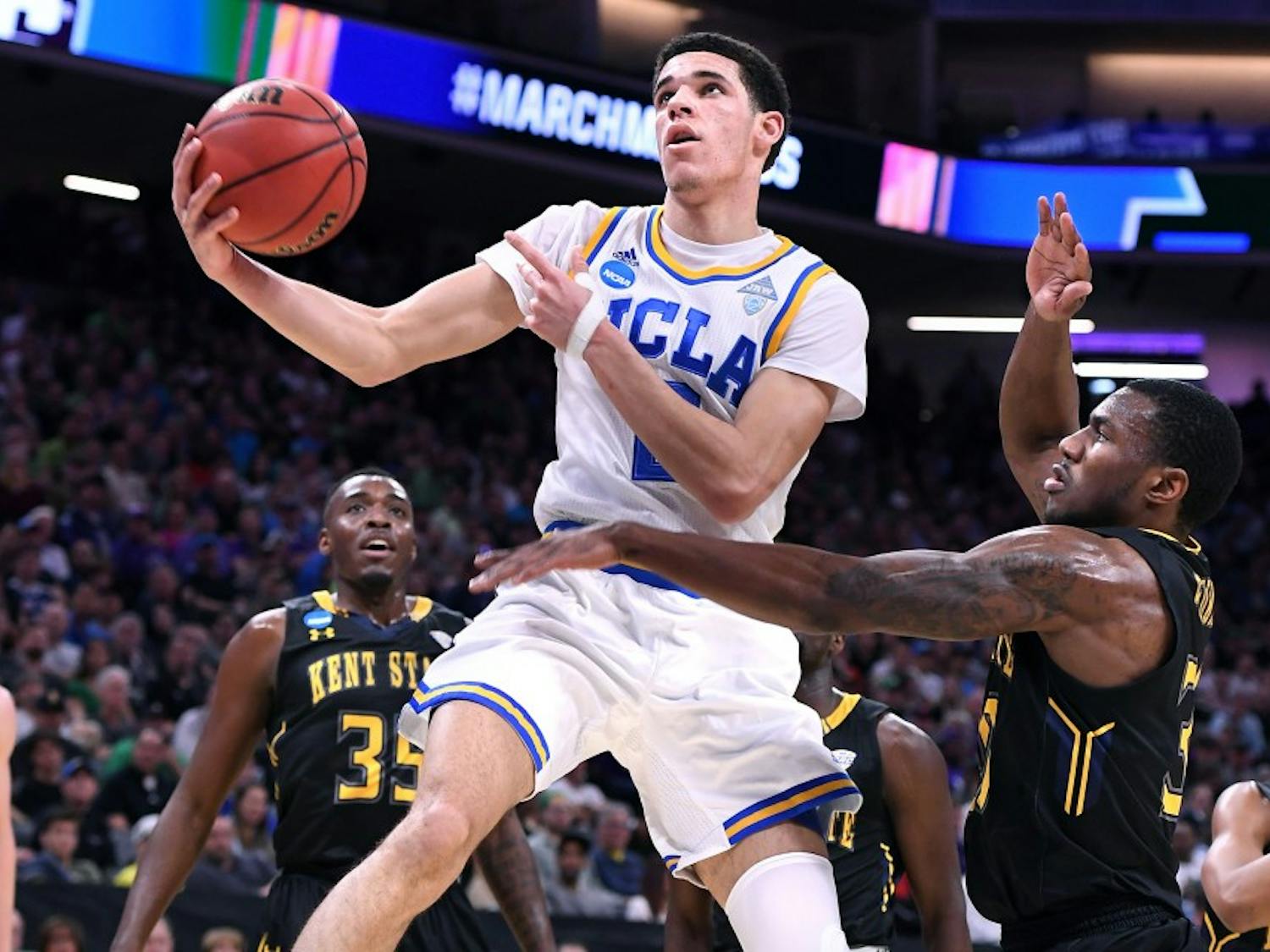 UCLA's Lonzo Ball, middle, scores a basket and draws a foul against Kent State's Kevin Zabo during the first half in the first round of the NCAA Tournament at the Golden 1 Center in Sacramento, Calif., on Friday, March 17, 2017. UCLA advanced, 97-80. (Wally Skalij/Los Angeles Times/TNS)