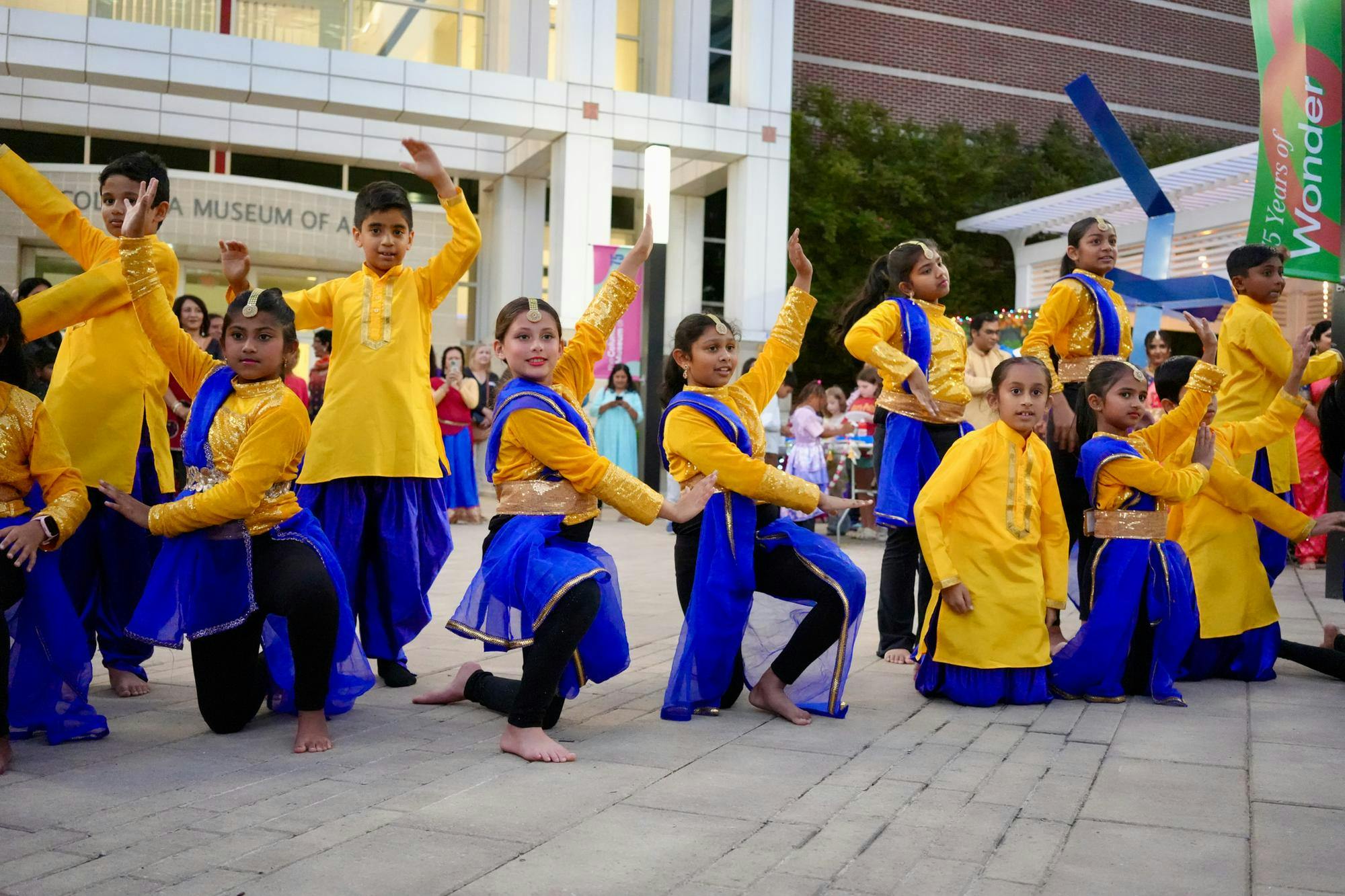 Children dressed in vibrant yellow and blue costumes perform a synchronized dance during the Diwali Kickoff Party on Oct. 16, 2025, at the Columbia Museum of Art in Columbia, South Carolina. The event highlighted the cultural diversity of the community through music, dance and celebration.
