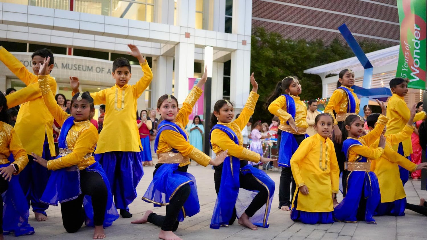 Children dressed in vibrant yellow and blue costumes perform a synchronized dance during the Diwali Kickoff Party on Oct. 16, 2025, at the Columbia Museum of Art in Columbia, South Carolina. The event highlighted the cultural diversity of the community through music, dance and celebration.
