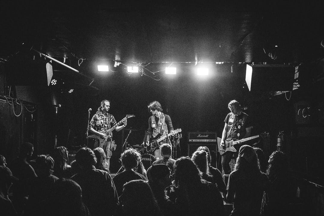 Bleeding Trees members, (from left to right) guitarist Gavin Seboe, guitarist and vocalist Jeremy Wheeler and bassist Boodrix Seboe, perform at New Brooklyn Tavern on Aug. 21, 2022 dressed up as Lowe's employees. The alternative grunge emo band said it finds inspiration in their music from a mix of religion, anime, funk and metal bands like Metallica and Megadeath. &nbsp;
