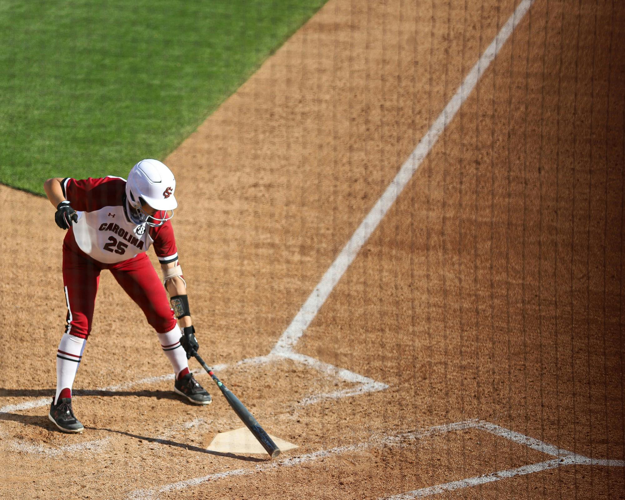 &nbsp;Senior designated player Alyssa Kumiyama taps home plate with her bat, preparing to swing at a pitch.&nbsp;