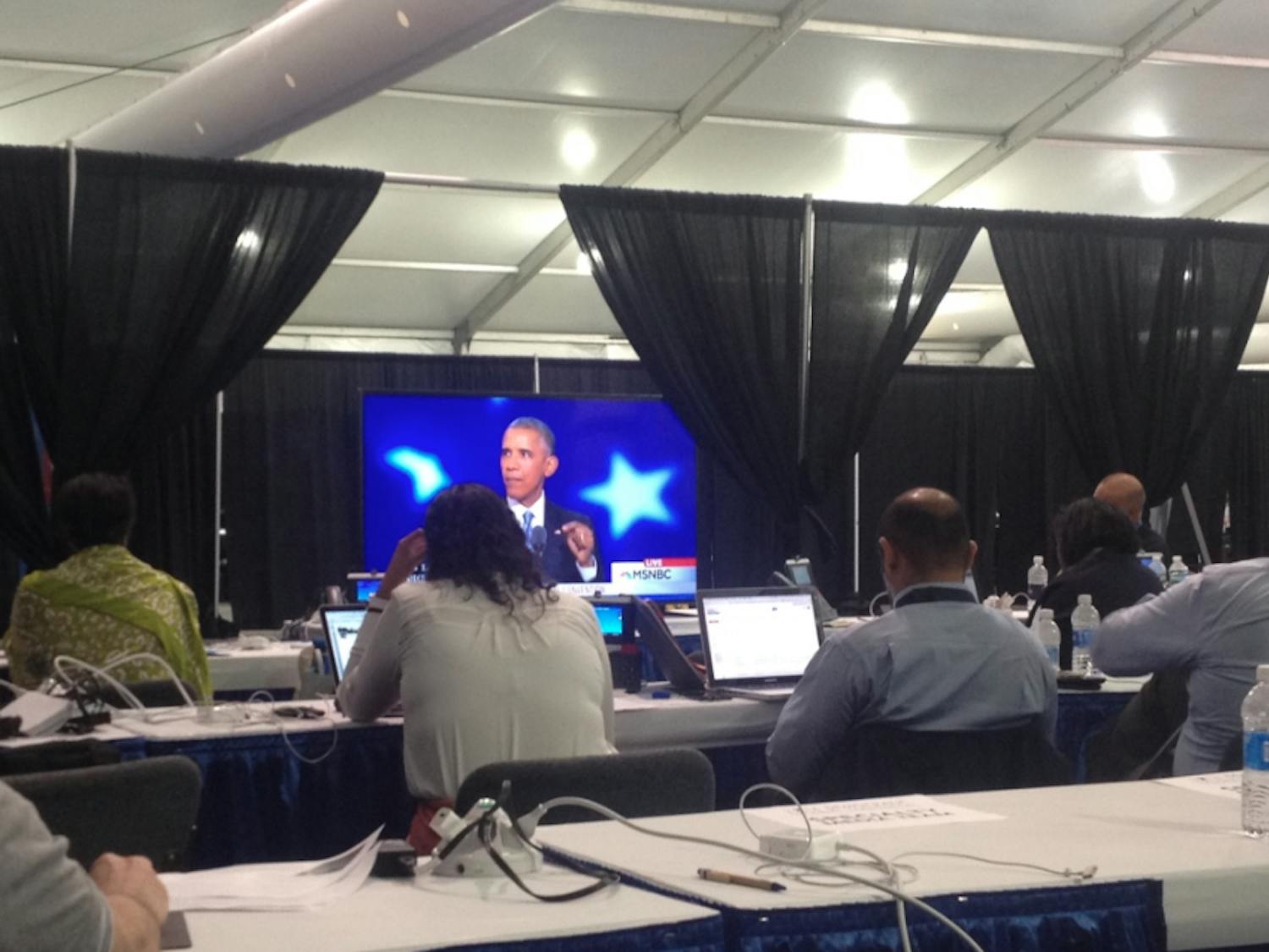 Reporters inside the media center watch remarks from President Barack Obama at the Democratic National Convention in Philadelphia on July 27, 2016.