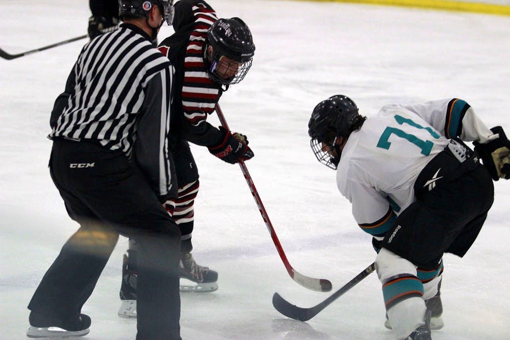 Jacob Tengi (black) takes on Brett Sireikis (71) in a puck drop.
