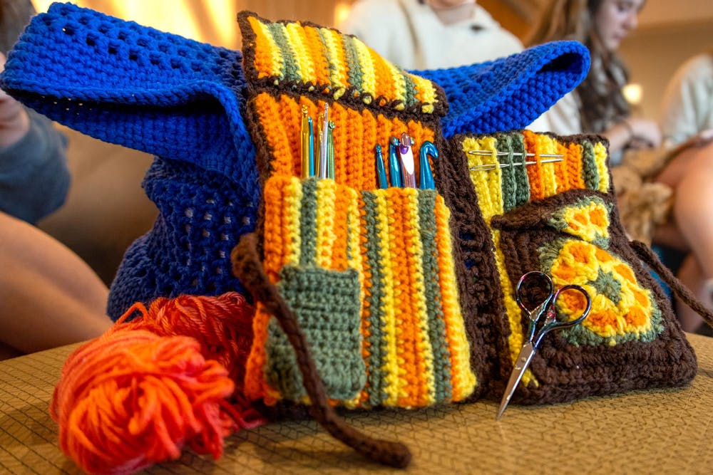 <p>A crocheted bag full of crocheting supplies sits on a stool in the Russel House during a Crochet Club meeting on Aug. 26, 2024. The Crochet club was founded in 2023 and allows members to learn and practice their work with other students.</p>