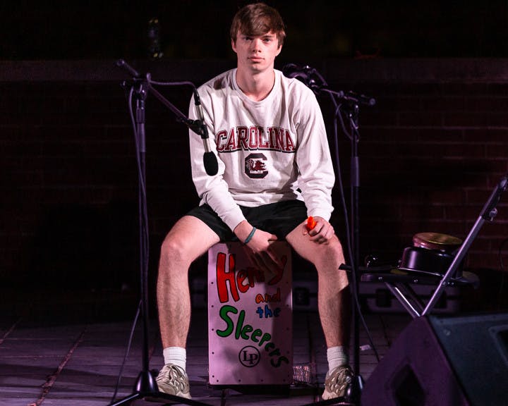 Second-year operations and supply chain student Sean Wright, the cajon drummer for Henry and the Sleepers, keeps the tempo during the band's set at the Battle of the Bands on Oct. 5, 2022. &nbsp;The competition brought acappella, folk, rap and rock to the Russel House Patio in a variety of performances.&nbsp;