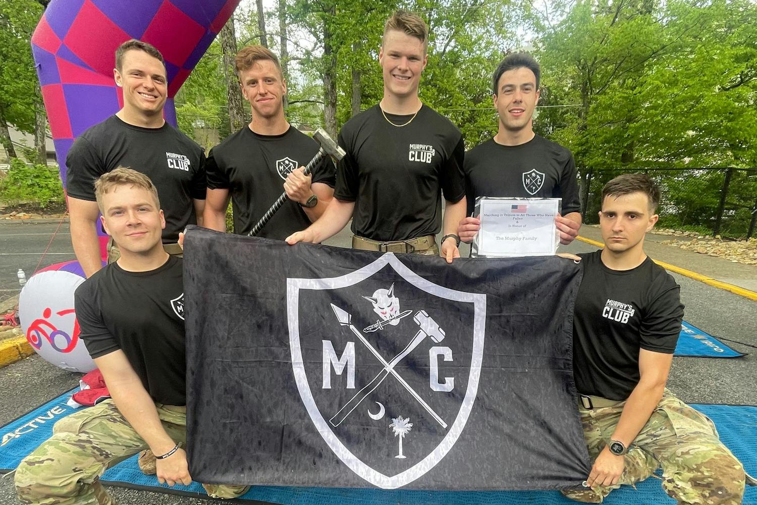 Members of Murphy's Club pose with the organization's flag at the 2023 Mountain Man Memorial March. The group took part in the Mountain Man Memorial March's marathon, where participants ran through the mountains of Tennessee wearing 35 pounds on their backs.