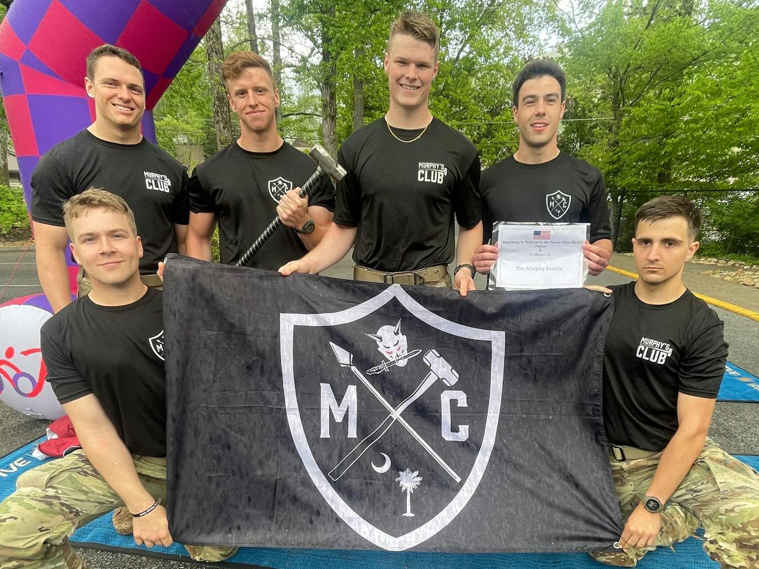 Members of Murphy's Club pose with the organization's flag at the 2023 Mountain Man Memorial March. The group took part in the Mountain Man Memorial March's marathon, where participants ran through the mountains of Tennessee wearing 35 pounds on their backs.