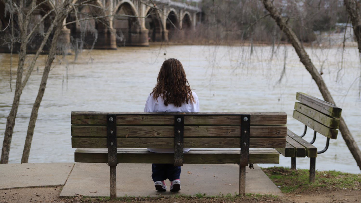 A person sits on a bench at The Riverwalk Park on Feb. 1, 2023. The park is a great place for students to go to relax and relieve some stress.