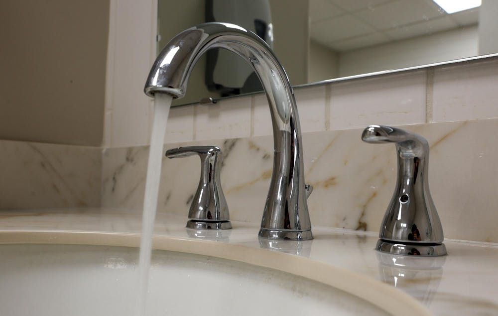 <p>Water flows steadily from a chrome bathroom faucet into a sink beneath a mirror.</p>