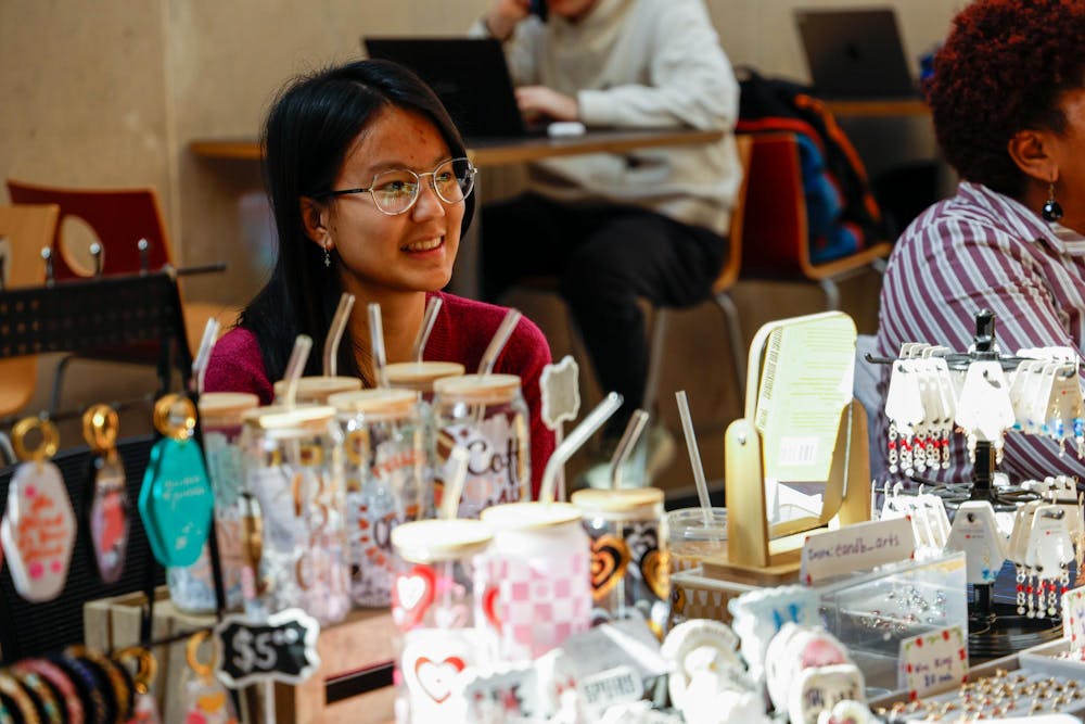 <p>Second-year anthropology student Ellie Dawkins smiles while sitting behind her booth at a tabling event for Student Made USC in Russell House on Feb. 17, 2025. Dawkins is the owner of B and E Arts, which sells handmade jewelry and other accessories.</p>