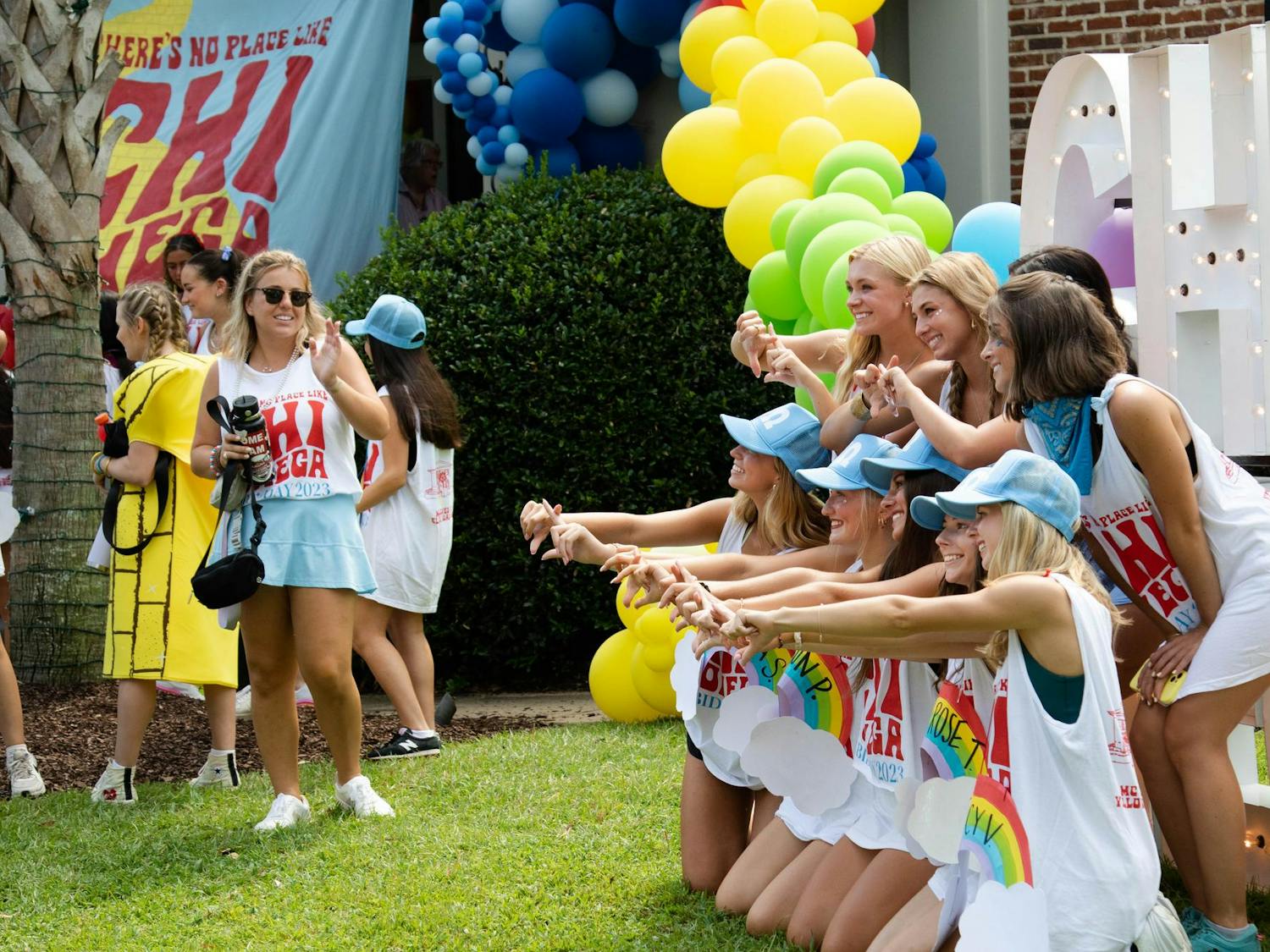 Yellow sidewalks and balloons decorate the Chi Omega house in Greek Village on Aug. 27, 2023. New members and sisters posed on the lawn for pictures to commemorate the excitement of Bid Day.