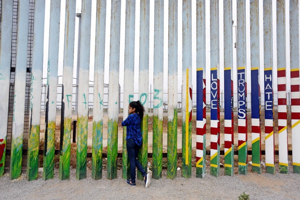 Jade Vega, 14, of Peru, peers through the fence at Friendship Park at the beach along the U.S.-Mexico border in Tijuana, Baja Calif., on July 29, 2017. Vega, who says she is a U.S. citizen, was visiting her mother in Tijuana for the summer. (Gary Coronado/Los Angeles Times/TNS)