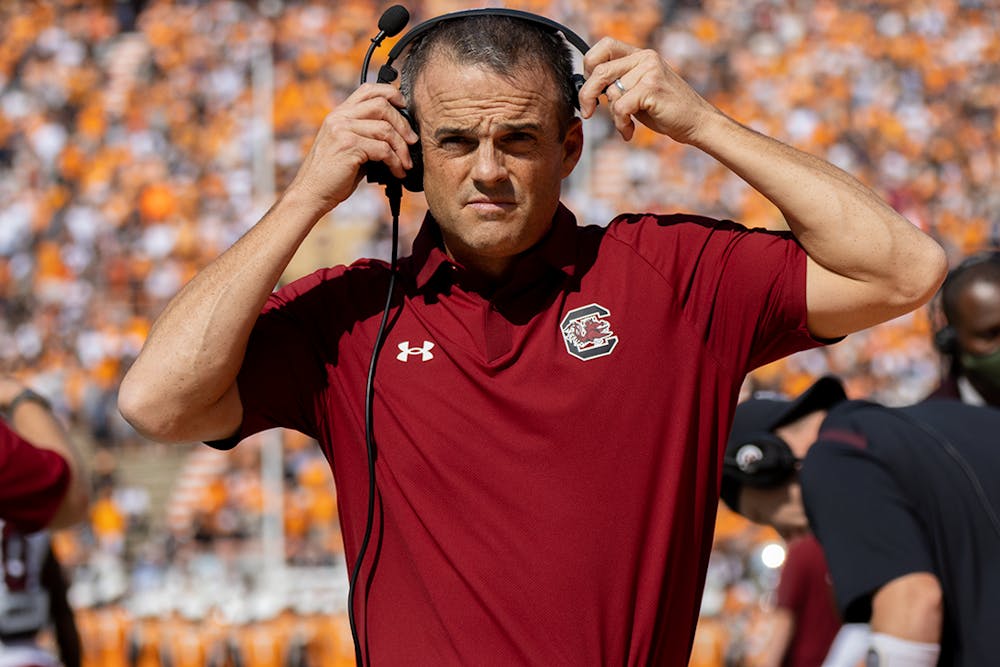 Gamecocks football head coach Shane Beamer puts on his headset while facing off Tennessee at Neyland Stadium on Oct. 9, 2021.