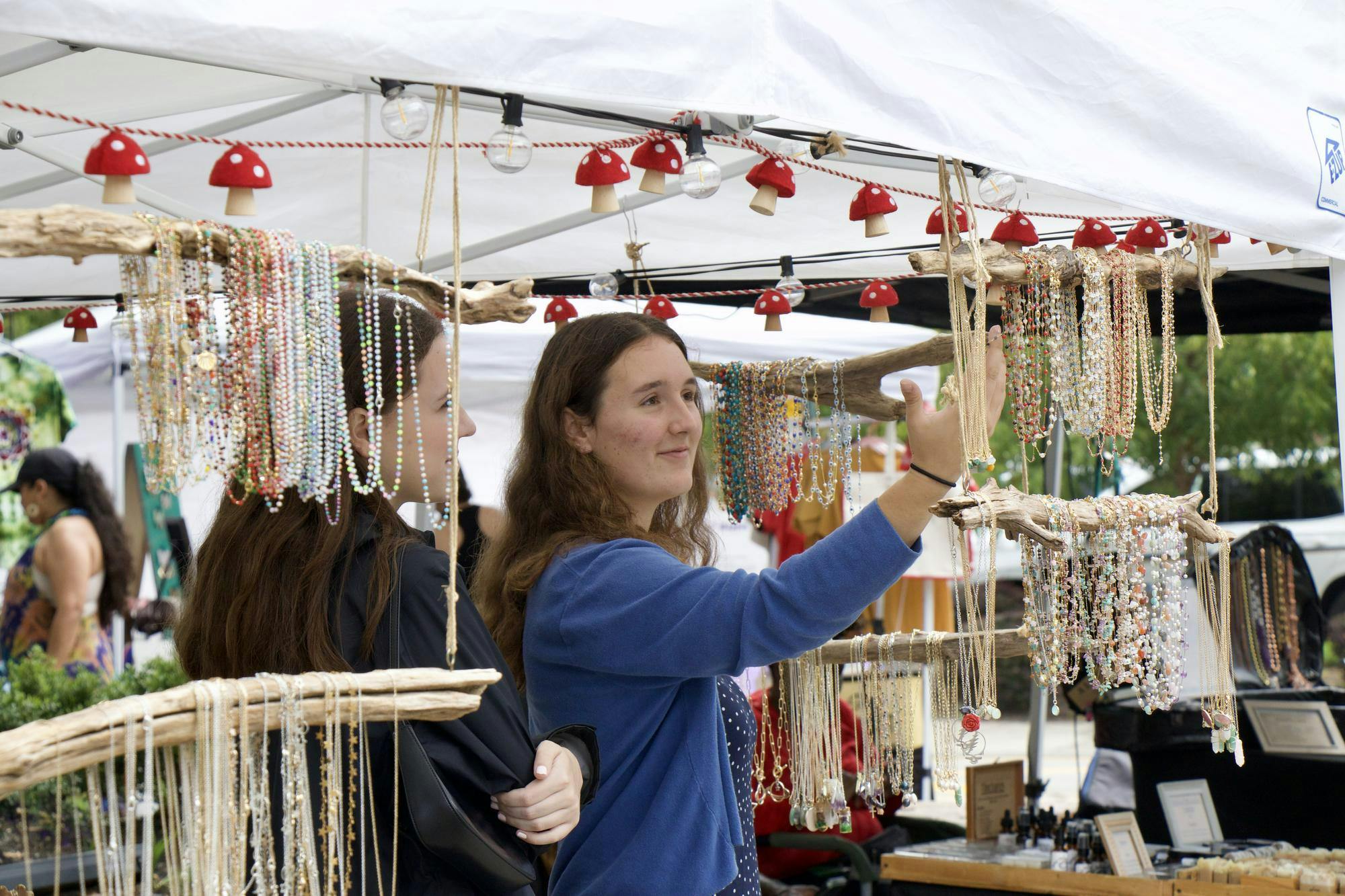 Kate Dowhy and Anna McIntyre check out one of the vendors after stumbling upon JerryFest for the first time on Oct. 5, 2025. Les Bijoux, a jewelry vendor at the festival, is owned by Karen Lawler from Augusta, South Carolina.