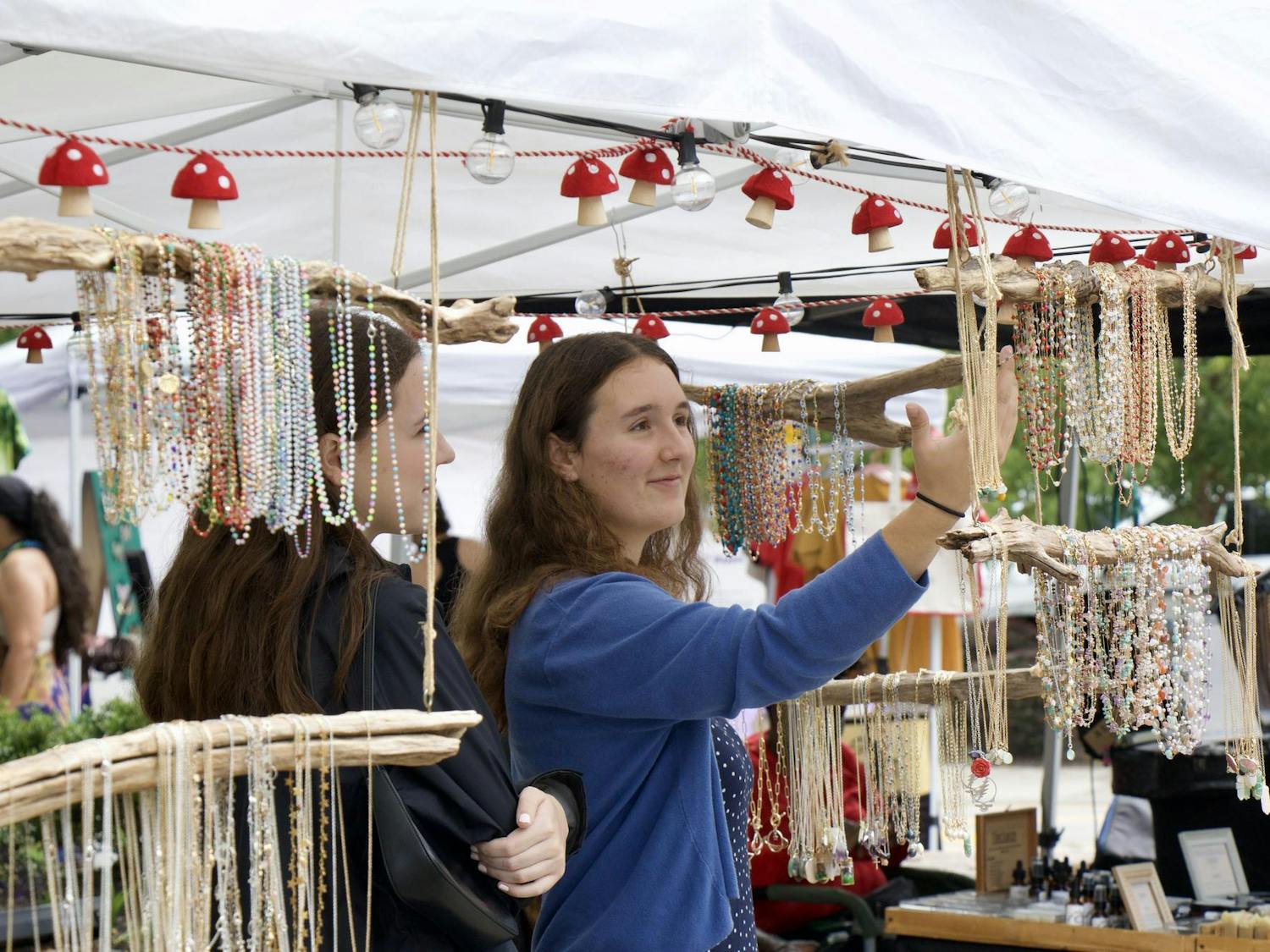 Kate Dowhy and Anna McIntyre check out one of the vendors after stumbling upon JerryFest for the first time on Oct. 5, 2025. Les Bijoux, a jewelry vendor at the festival, is owned by Karen Lawler from Augusta, South Carolina.