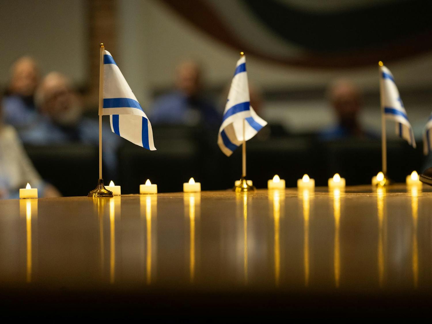 Israeli flags line the stage of the Russell House Theater during the Israel Solidarity Rally on Oct. 7, 2024. Mini Israeli and American flags were distributed, and Columbia resident Bruce Fox brought his own standard size flag that he purchased two months ago, motivated by his love for Israel.