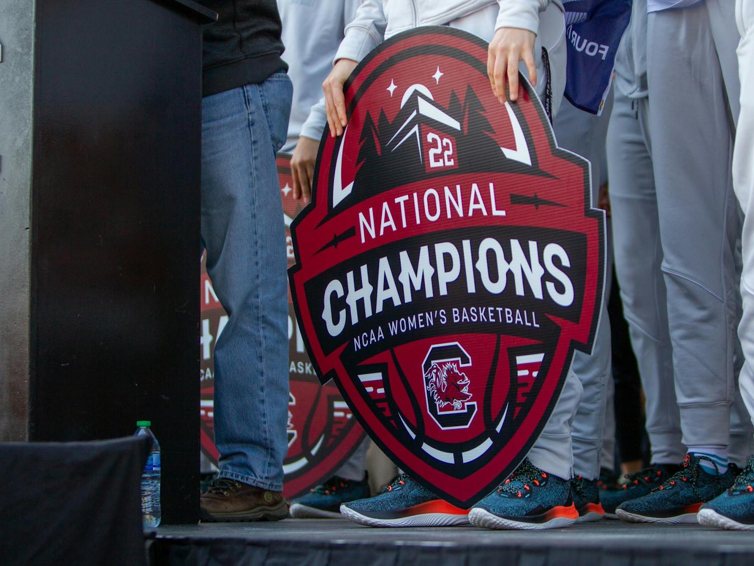 Members of the South Carolina women's basketball team hold a national champions sign outside of Colonial Life Arena on April 4, 2022. The Gamecocks defeated the University of Connecticut 64-49 to claim their second national title.