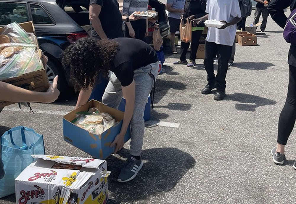 <p>Third-year electrical engineering student Ramy Alawar organizing food that will be passed out to the homeless population of Finlay Park.</p>