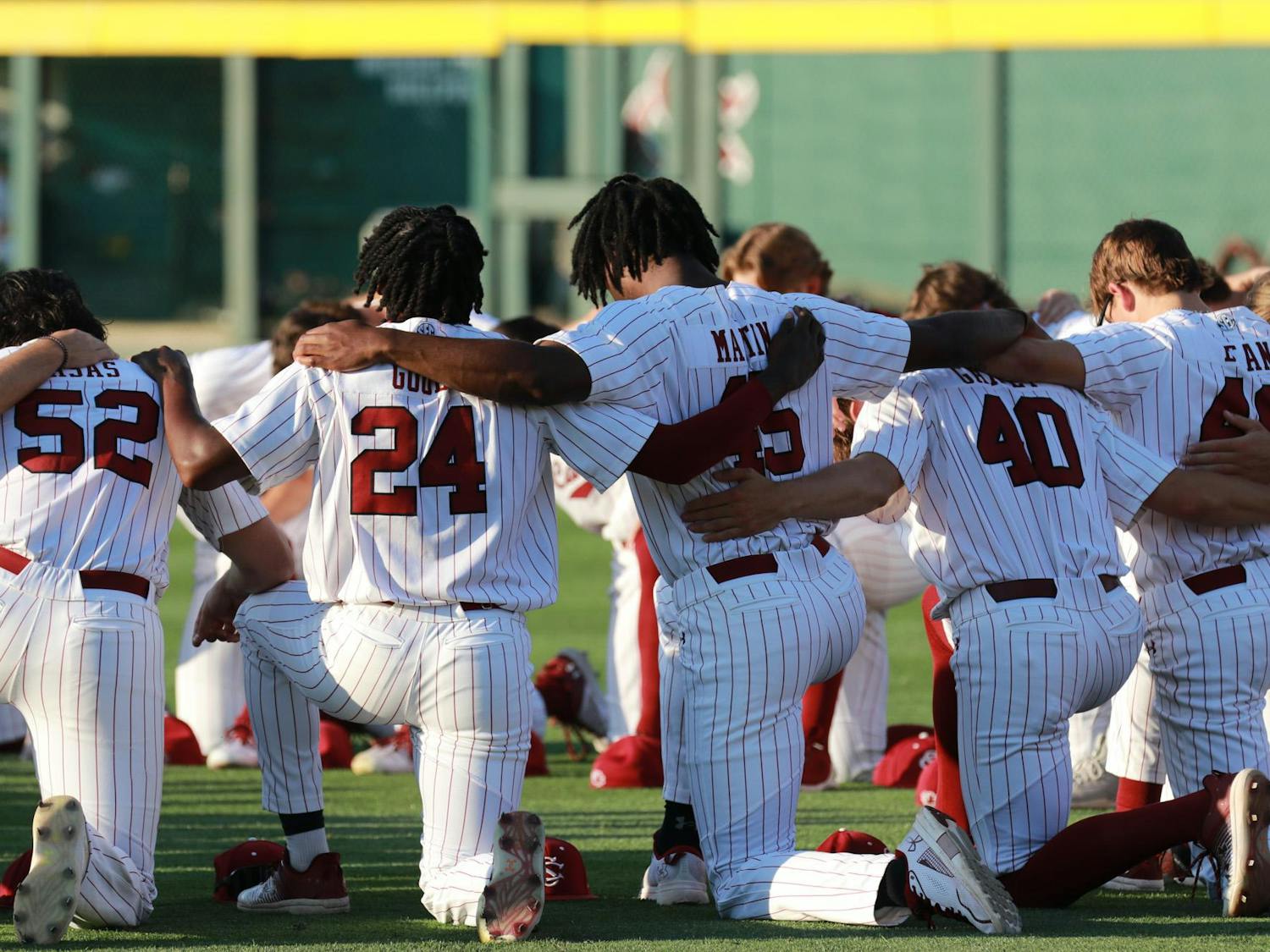 South Carolina baseball players kneel in a circle and pray as part of the team's pre-game ritual on April 19, 2024, at Founders Park. The No. 20 Gamecocks were defeated by the No. 2 Arkansas Razorbacks 2-1 in the first game of the weekend series.