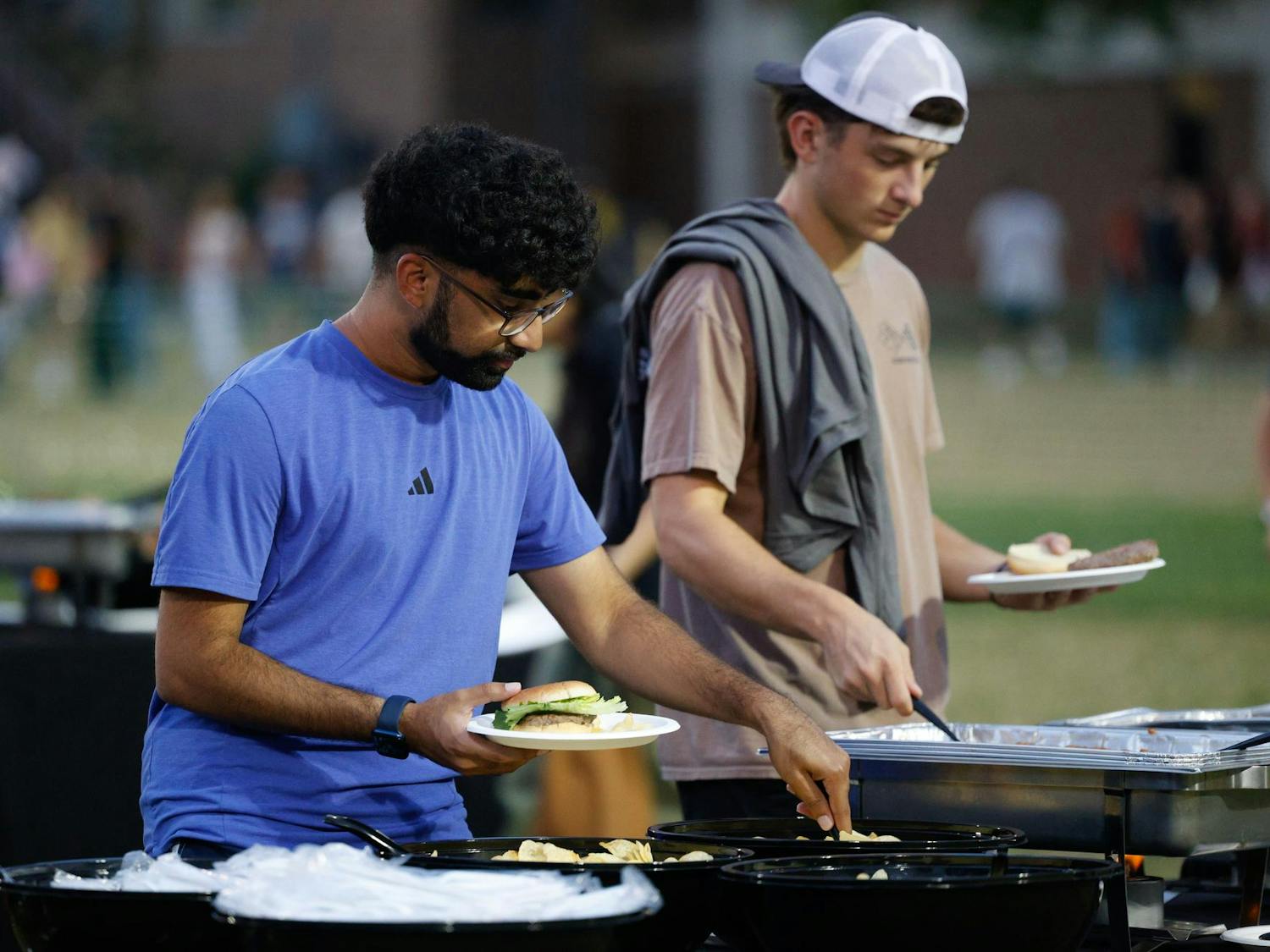 A student scoops chips onto his plate at the food tables at Blatt Bonanza on Sept. 18, 2024, at Blatt Field. The event was put on by a variety of organizations across campus.