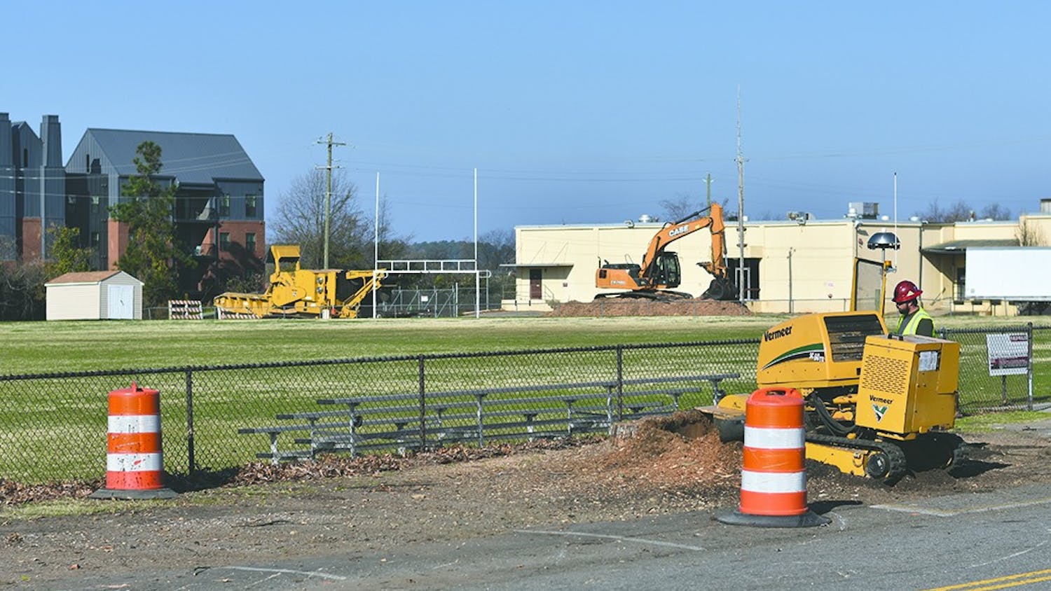 A worker grinds down a tree stump as construction begins on the new parking lot at the Greene Street Fields across from Colonial Life Arena.