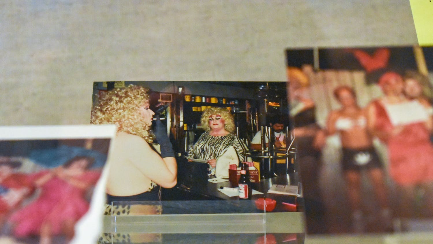 A photo of a patron at Affairs, a bar located at 712 Huger St., sits in the “To tell the secret of my nights and days" exhibit. The photo is among multiple photos of the "camp drag shows" held at Affairs that are now on display until late January 2024.