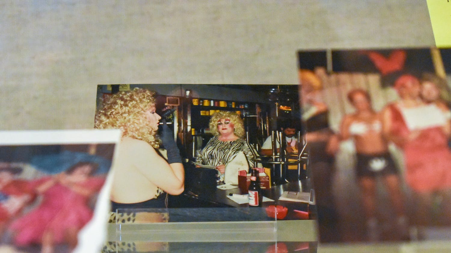 A photo of a patron at Affairs, a bar located at 712 Huger St., sits in the “To tell the secret of my nights and days" exhibit. The photo is among multiple photos of the "camp drag shows" held at Affairs that are now on display through January 2024.