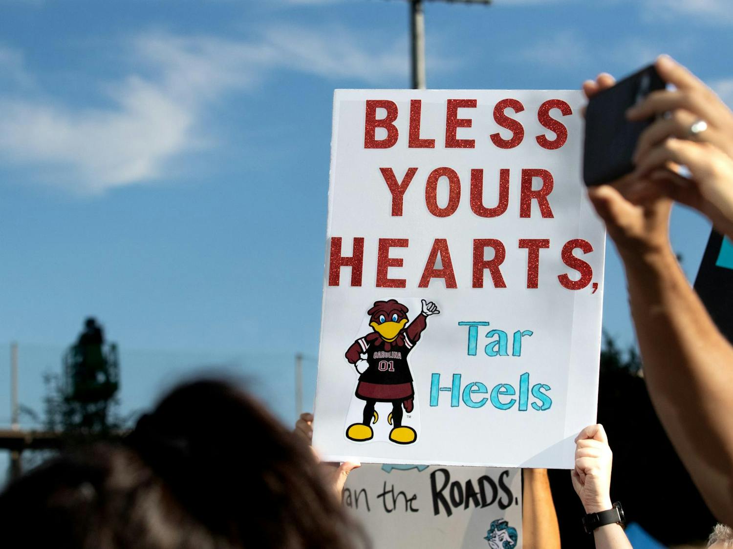 A sign saying “Bless your hearts, Tar Heels” is held by a South Carolina fan in Charlotte on Sept. 2, 2023. Fans gathered in Charlotte before the football game between South Carolina and North Carolina.