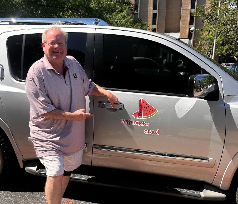<p>Columbia resident Mike Sloan poses with his car, the "Watermelon Crawl.” Sloan promotes rideshare safety at USC.</p>