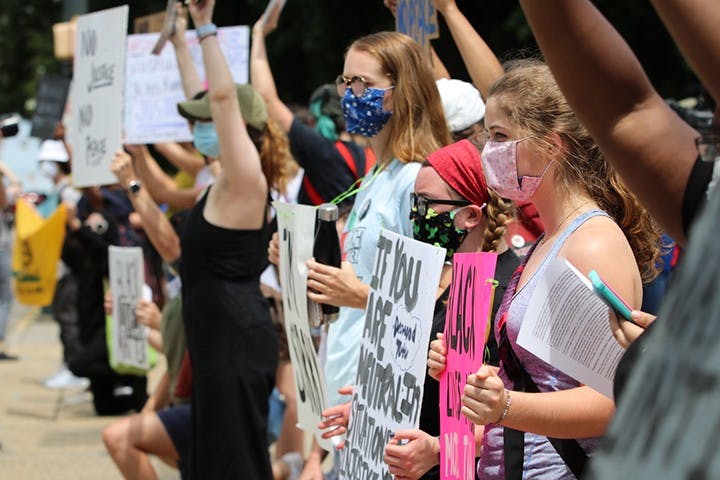 Protestors lined the street in front of the Statehouse facing watching police officers. Many cars honked in support as they drove past the protestors.&nbsp;