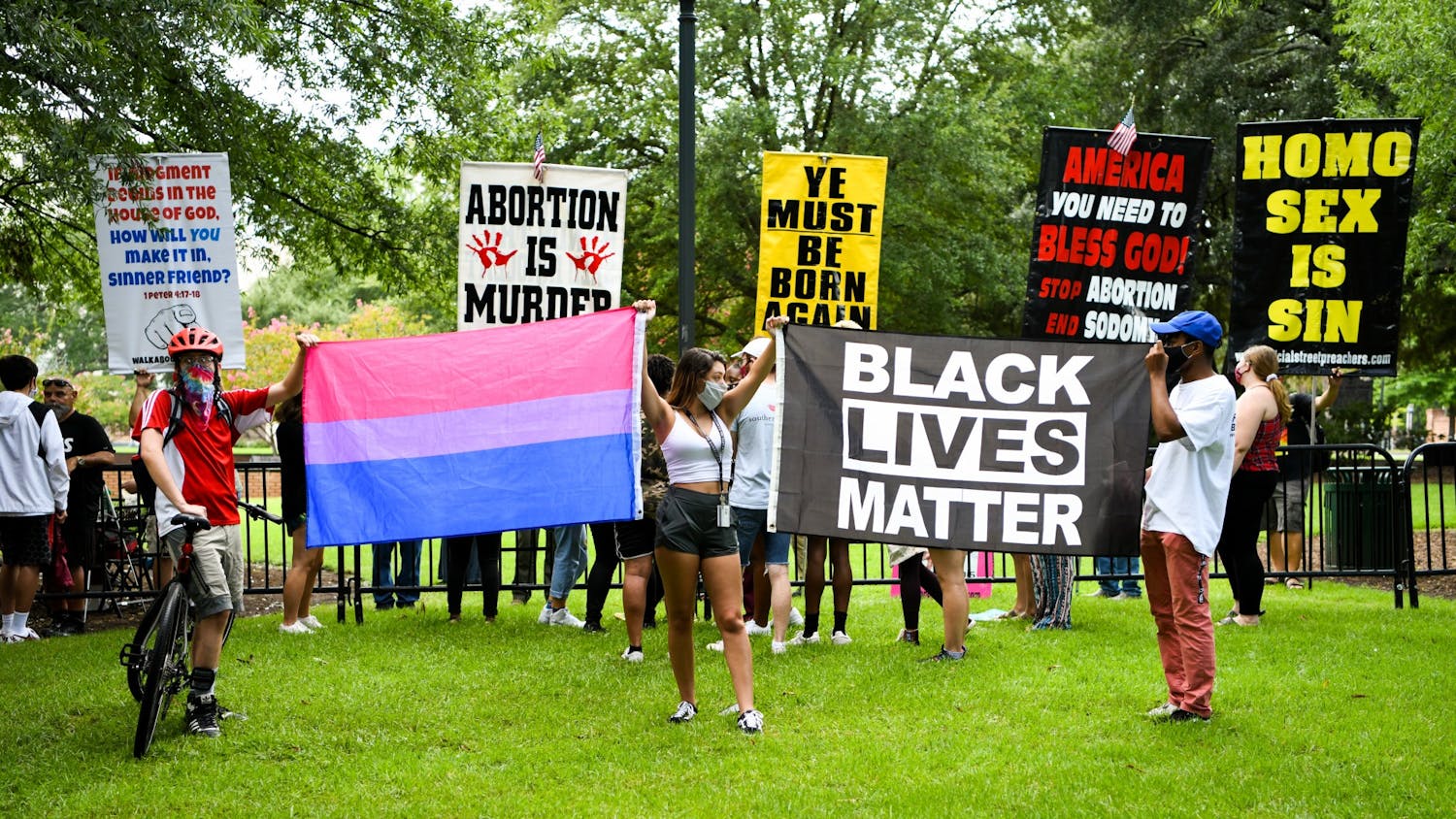 University of South Carolina students hold a transgender pride flag and a Black Lives Matter flag in front of protestors on campus on Aug. 26, 2020.