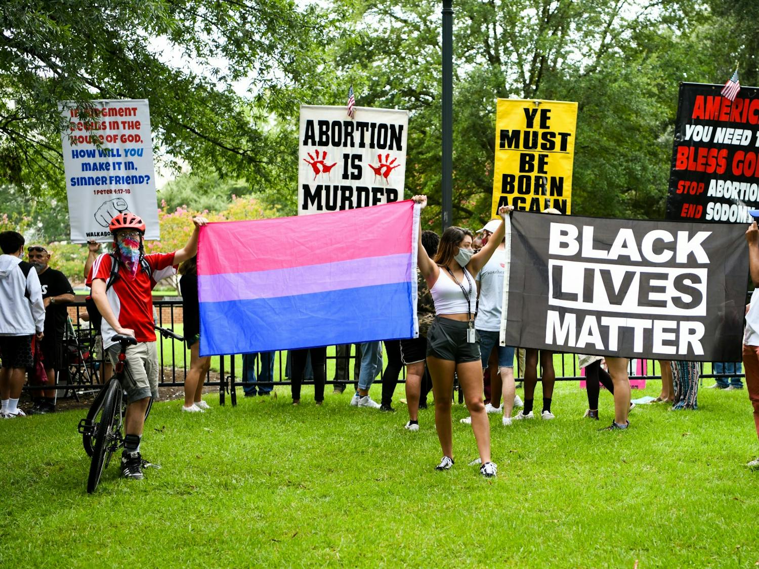 University of South Carolina students hold a transgender pride flag and a Black Lives Matter flag in front of protestors on campus on Aug. 26, 2020.