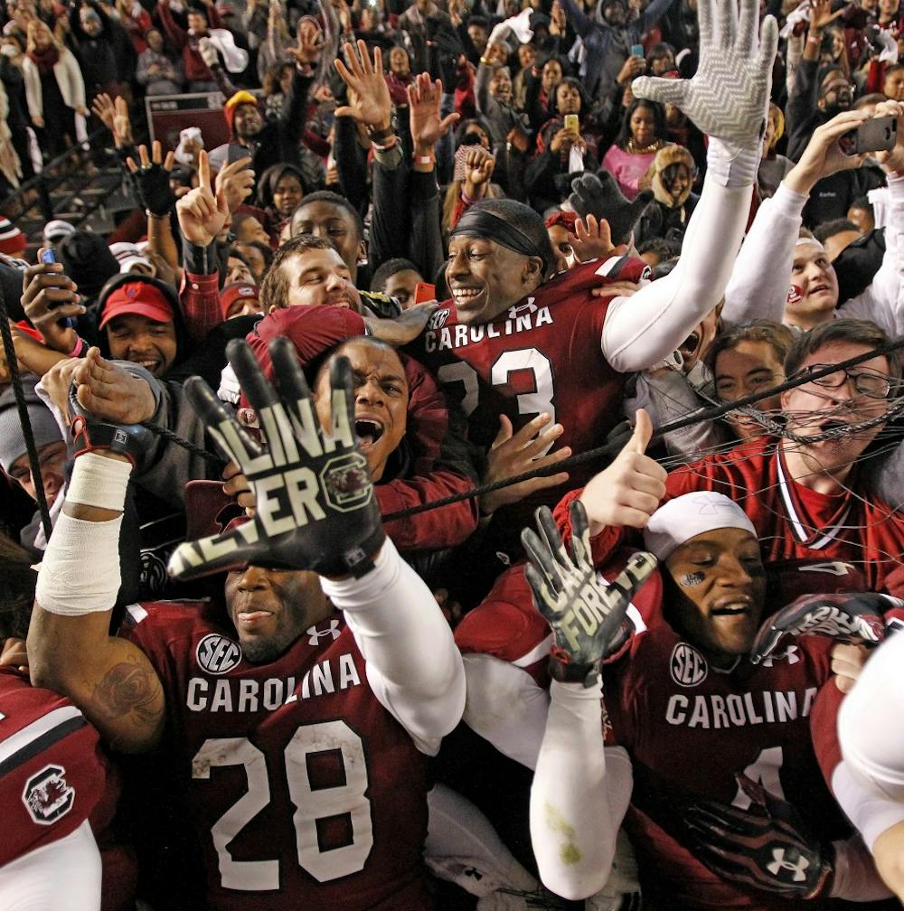 South Carolina players celebrate with fans after a 31-17 win win against Clemson at Williams-Brice Stadium in Columbia, S.C., on Saturday, Nov. 30, 2013. (Gerry Melendez/The State/MCT)