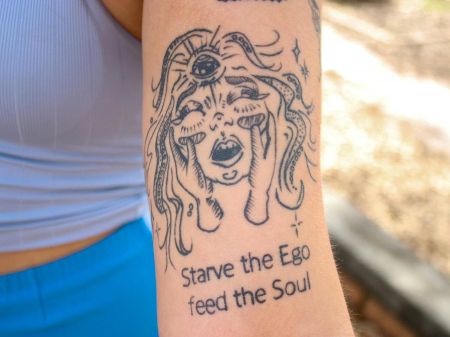 Sandford refers to this tattoo as “my girl.” “I look at this, and I feel it in my bones,” Sandford said. She noted the importance of the script beneath the face, reading “Starve the Ego, feed the Soul.” She said this phrase serves as a reminder to strip herself down and not put more ego into a world that has enough of it.
