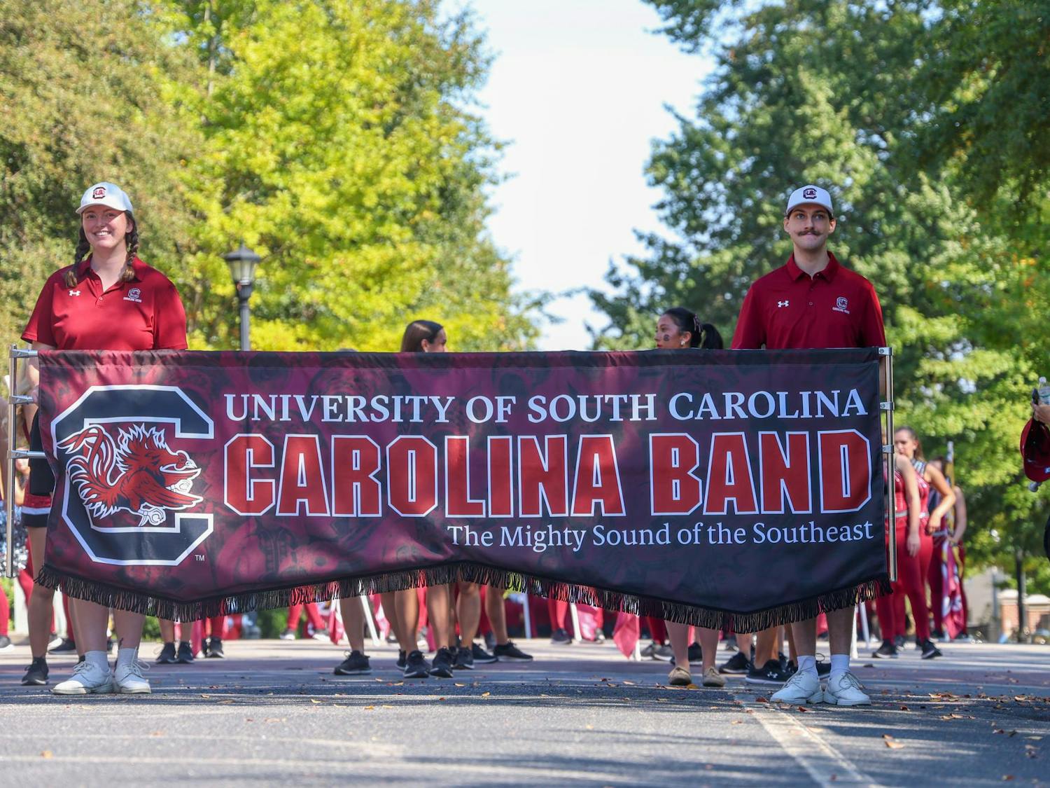 Two members of the Carolina Band carry the band's banner while the band practiced marching down Greene Street on Oct. 26, 2024. The band marched from Russell House to the State House to practice for their upcoming performance in the Macy's Thanksgiving Day Parade.