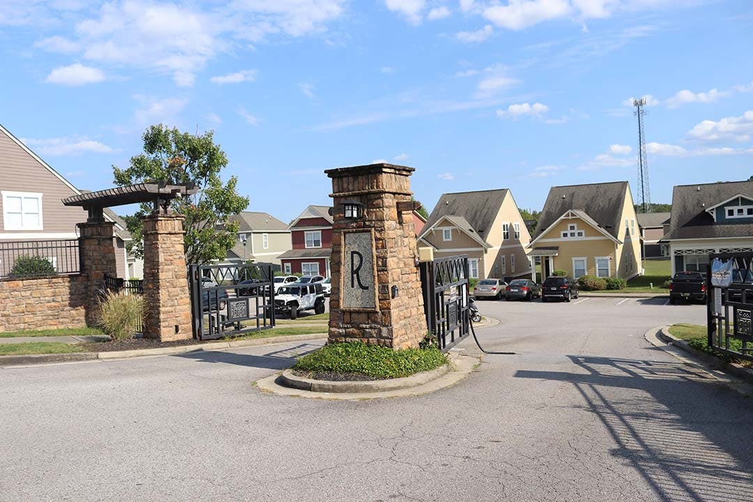 The rear entrance of The Retreat located off Zion Rd. A piece of metal is hanging off the gate in the path of vehicles.