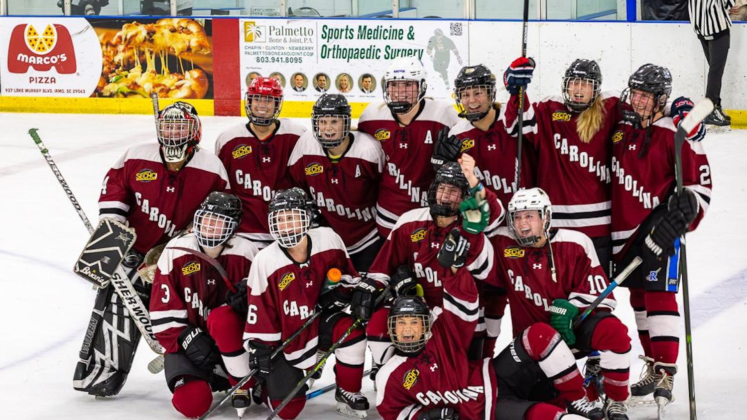 The University of South Carolina's women's hockey team huddles together for a team photo after its 2-1 victory against the South Carolina Lady Warriors on Oct. 1, 2023, in Irmo, South Carolina. This matchup marks the first collegiate women's hockey game to be played in the 247-year history of South Carolina.