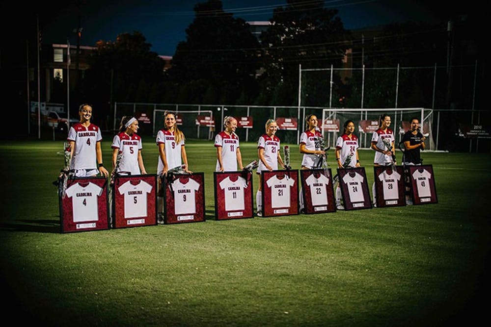 The seniors for the women's soccer team stand behind their framed jerseys. The team beat Mississippi State University 2-0 Friday, Oct. 30.