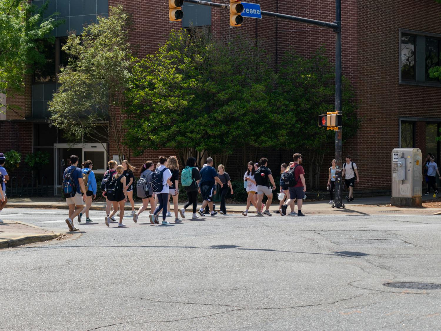 Student pedestrians cross the intersection of Greene and Sumter Streets on April 5, 2023. This intersection is often one of the busiest on campus and is often jaywalked by students despite frequent traffic.