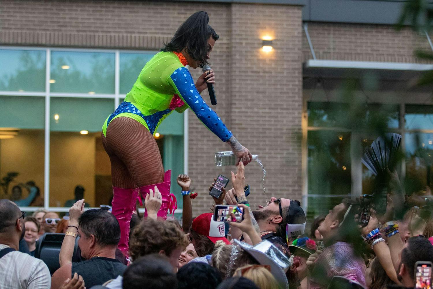Drag performer Vanessa Vanjie Mateo pouring a drink down an audience member's mouth during Outfest on June 1, 2024. Outfest Columbia is a one-day event that showcases drag talent, businesses, and vendors from across South Carolina.