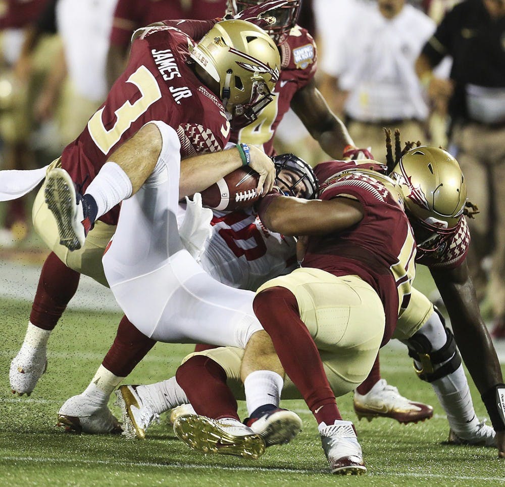 Ole Miss quarterback Chad Kelly (10) is crunched by Florida State defensive back Derwin James (3) and others during the Florida State vs. University of Mississippi college football game on Monday, Sept. 5, 2016 at Camping World Stadium in Orlando, Fla. (Stephen M. Dowell/Orlando Sentinel/TNS)