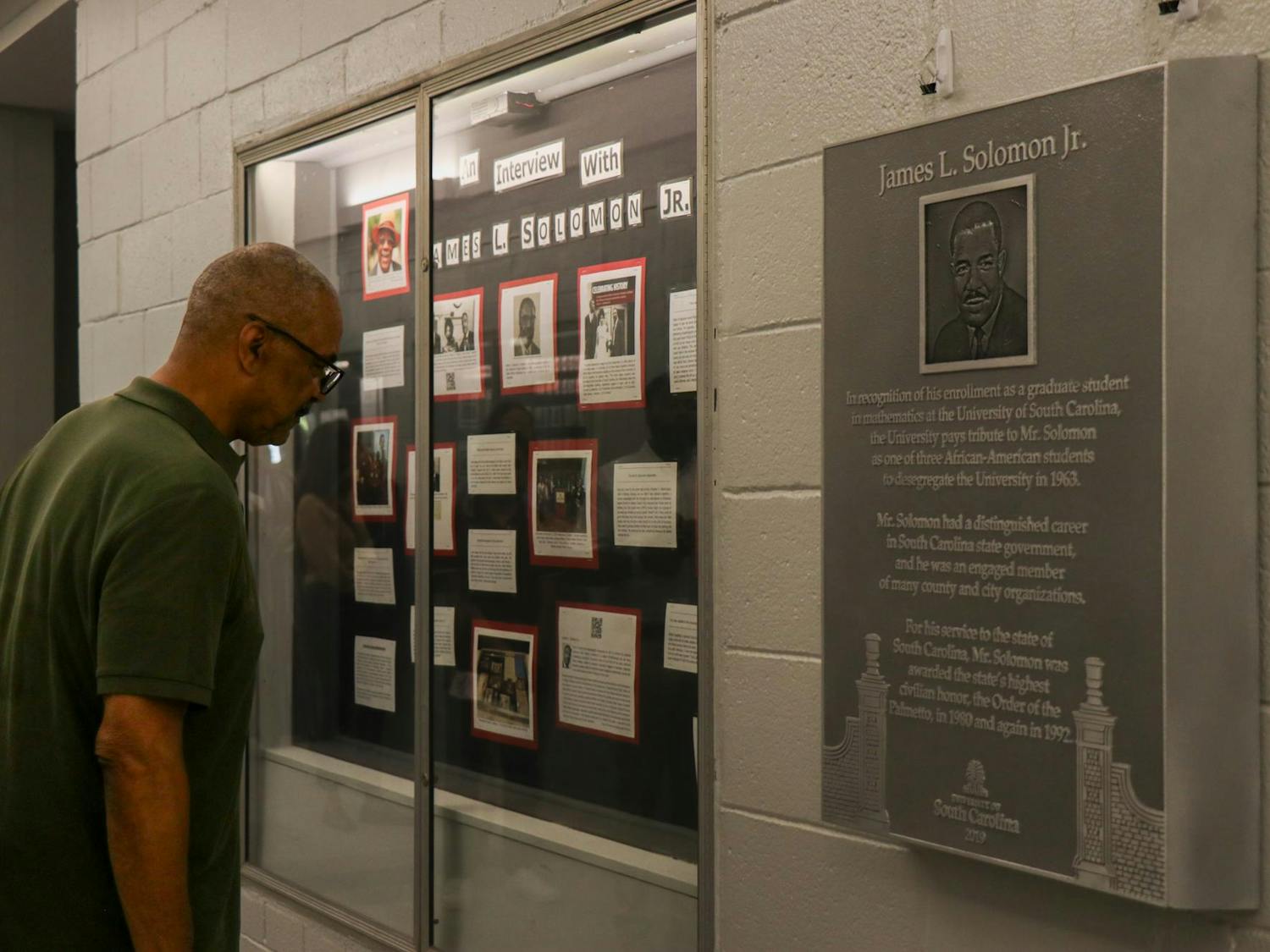 A person reads excerpts of an interview with James L. Solomon Jr. that are on display in LeConte College on Sept. 11, 2023. The College of Arts and Sciences unveiled a plaque in honor of Solomon Jr. four years after it was completed. The delay was caused by COVID-19 and construction.