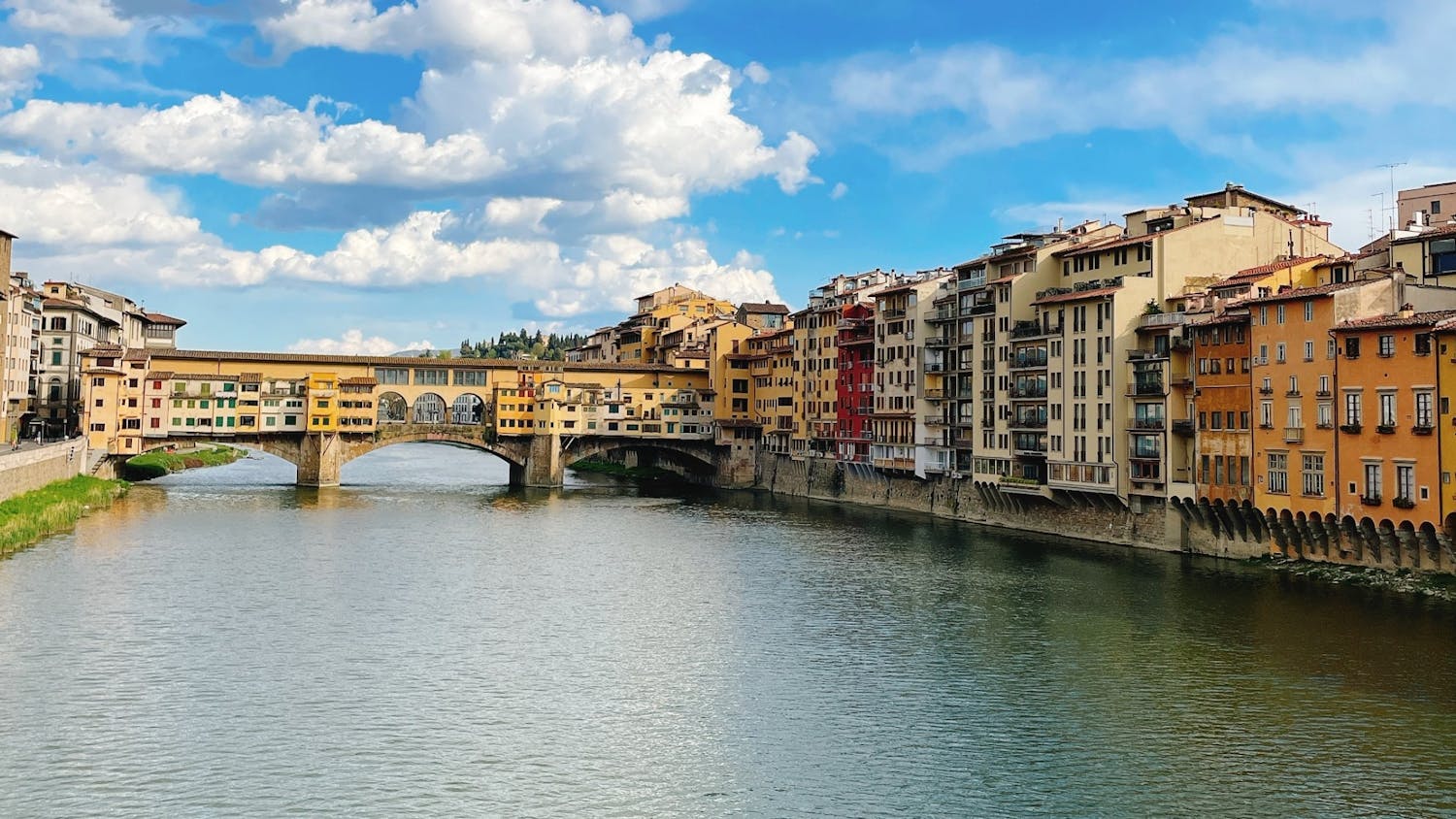 A canal in Florence, Italy, that is faced by buildings on each side and has a bridge to let pedestrians cross the canal.&nbsp;