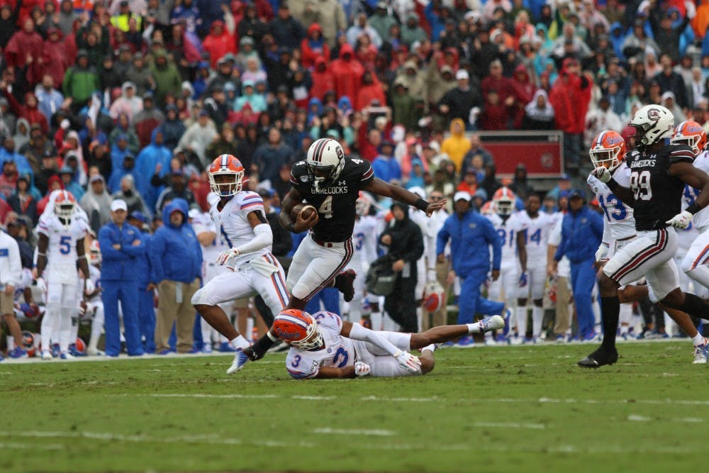 Senior running back Tavien Feaster runs with the ball during the game Saturday.