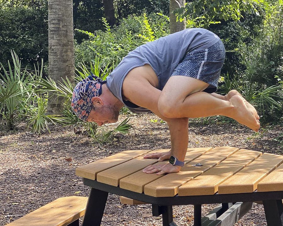 David Moscowitz, a professor at the School of Journalism and Mass Communications stands in the Bakasana yoga pose, a.k.a. the Crow Pose. Moscowitz offers donation-funded yoga lessons at Rooted Yoga, on Sunday afternoons.&nbsp;