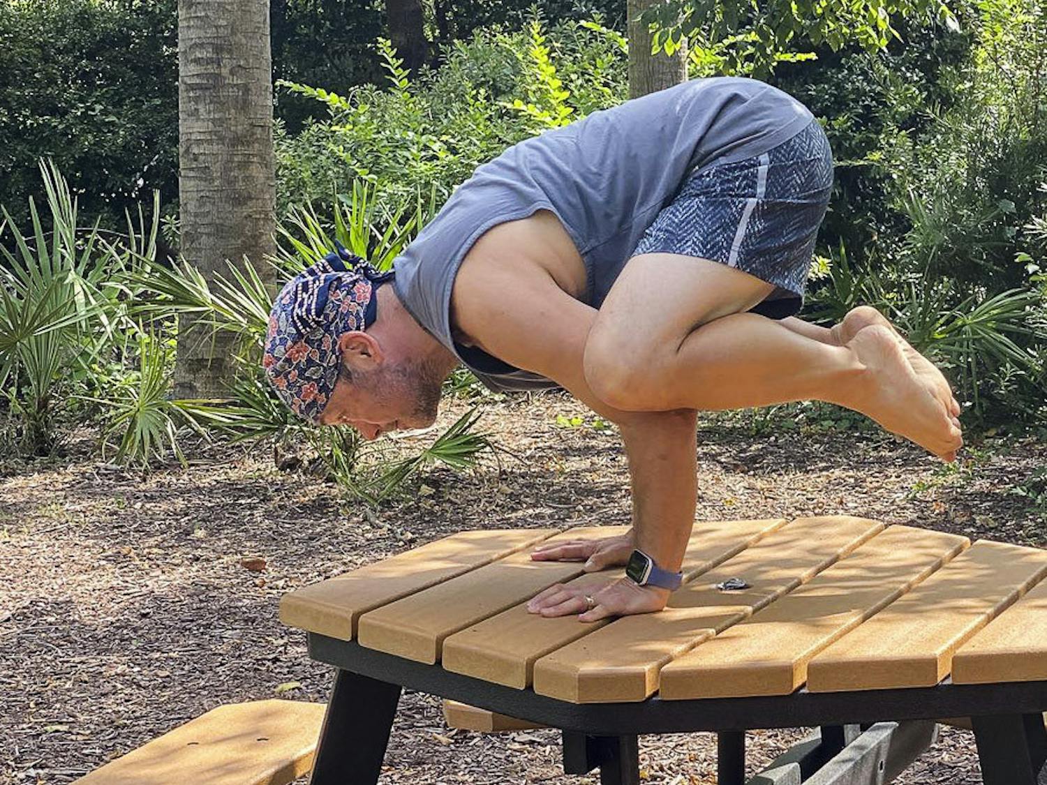 David Moscowitz, a professor at the School of Journalism and Mass Communications stands in the Bakasana yoga pose, a.k.a. the Crow Pose. Moscowitz offers donation-funded yoga lessons at Rooted Yoga, on Sunday afternoons.&nbsp;